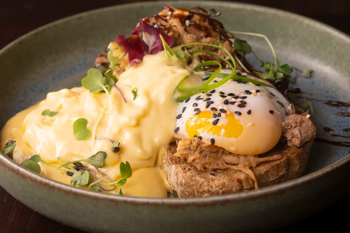 Huevos Benedict con pulled pork en salsa hoisin sobre pan de masa madre, huevo a baja temperatura con sésamo y salsa holandesa